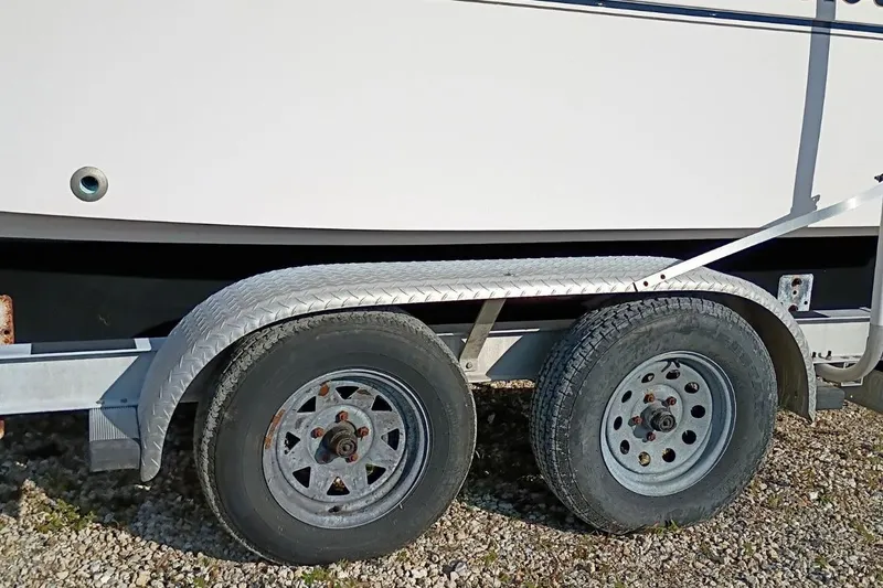 Slide: The Image of Trailer with dual wheels for 2004 Grady-White Escape 209 boat on gravel surface. - 29