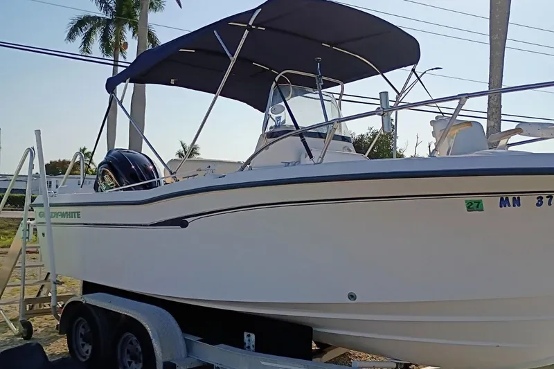 Slide: The Image of 2004 Grady-White Escape 209 boat on trailer with canopy, parked outdoors. - 30