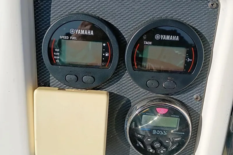 Slide: The Image of Yamaha gauges and Boss audio system on 2004 Grady-White Escape 209 boat dashboard. - 4