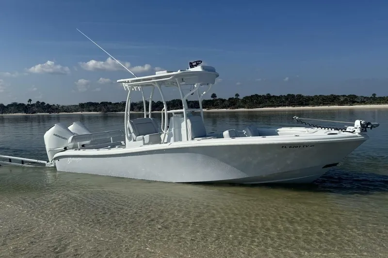 The Image of 2025 Yellowfin 26 Hybrid boat on calm water, clear sky background. - 0