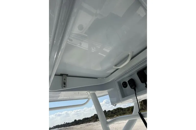 Slide: The Image of 2025 Yellowfin 26 Hybrid boat console with electronics, viewed from below, against a clear sky. - 15