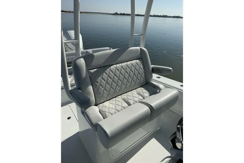 Slide: The Image of 2025 Yellowfin 26 Hybrid boat seat with quilted upholstery, overlooking calm water. - 18
