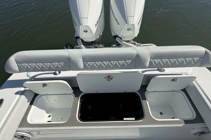 Slide: The Image of 2025 Yellowfin 26 Hybrid boat with open storage compartments and dual Mercury engines. - 24