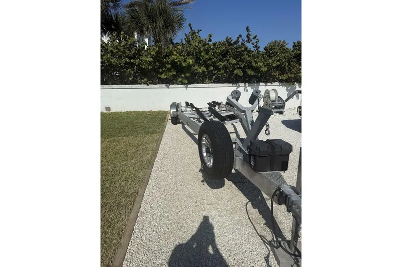 Slide: The Image of Trailer for 2025 Yellowfin 26 Hybrid boat on gravel driveway. - 31