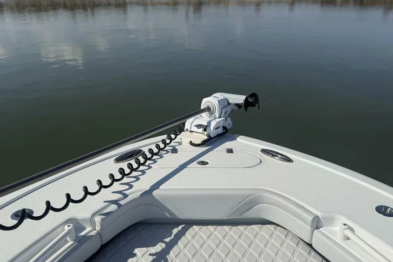 Slide: The Image of 2025 Yellowfin 26 Hybrid boat bow with trolling motor on calm water. - 4