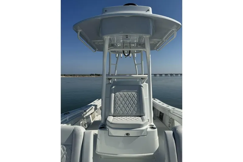 Slide: The Image of 2025 Yellowfin 26 Hybrid boat with sleek seating and T-top on calm water. - 7