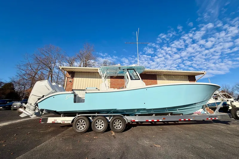 Slide: The Image of 2026 Yellowfin 36 Offshore boat on trailer, parked outdoors under clear blue sky. - 12