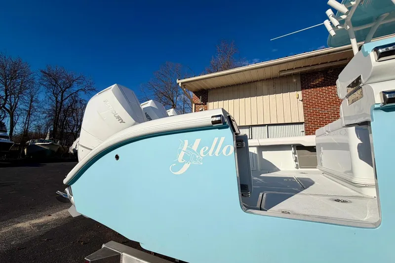 Slide: The Image of 2026 Yellowfin 36 Offshore boat with "Hello" text, parked outdoors under clear blue sky. - 13