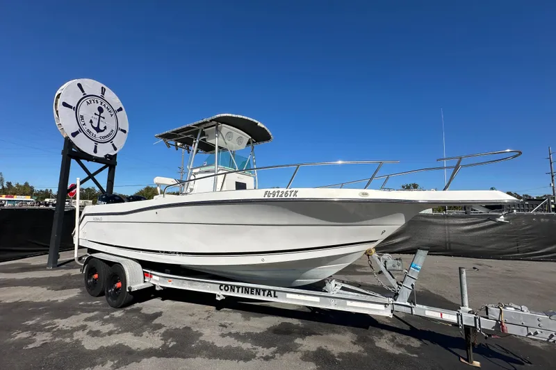 The Image of 1999 Robalo 2420 Center Console boat on trailer under clear blue sky. - 0