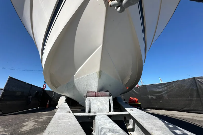 Slide: The Image of 1999 Robalo 2420 Center Console boat on trailer, viewed from below, against clear blue sky. - 11
