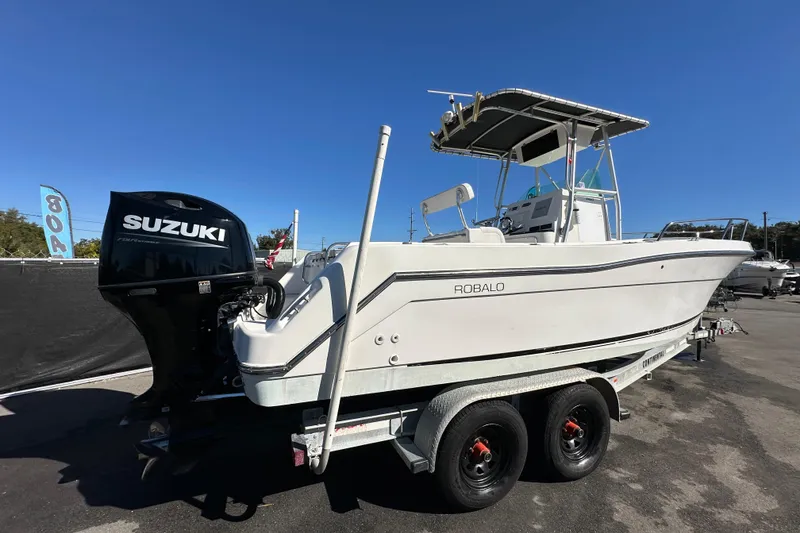 Slide: The Image of 1999 Robalo 2420 Center Console boat with Suzuki outboard motor on trailer. - 2