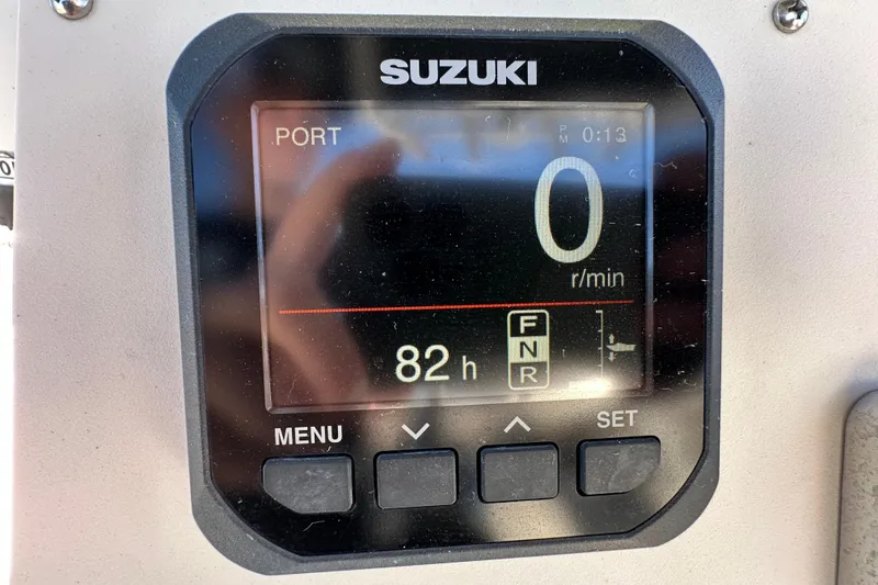 Slide: The Image of Suzuki boat display showing 0 RPM and 82 hours on a 1999 Robalo 2420 Center Console. - 21