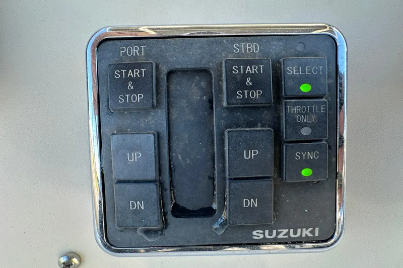 Slide: The Image of Control panel of a 1999 Robalo 2420 Center Console boat with Suzuki engine controls. - 23