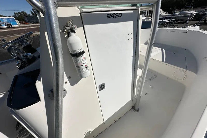 Slide: The Image of 1999 Robalo 2420 Center Console boat interior with fire extinguisher and steering wheel. - 28