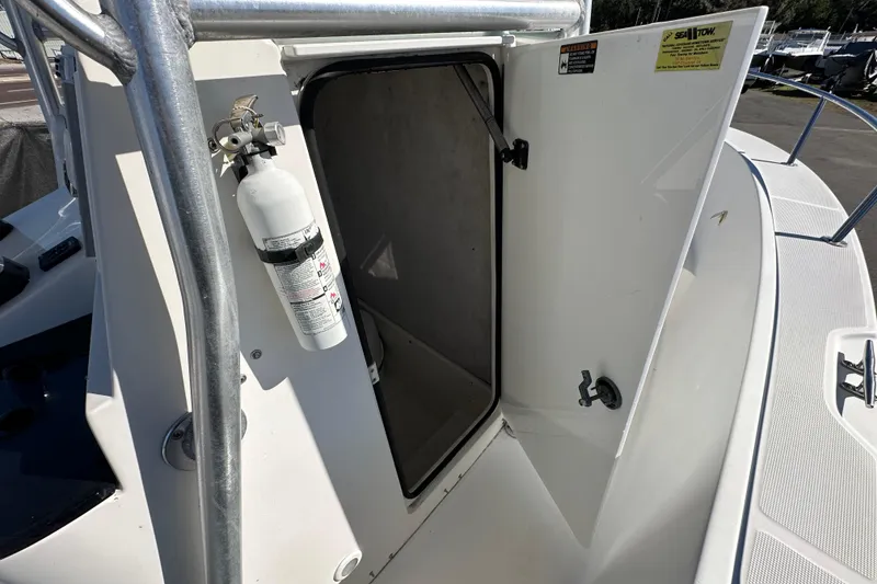 Slide: The Image of 1999 Robalo 2420 Center Console boat with open storage compartment and fire extinguisher. - 29