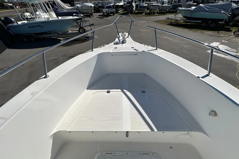 Slide: The Image of 1999 Robalo 2420 Center Console boat deck, featuring spacious seating and stainless steel railings. - 33