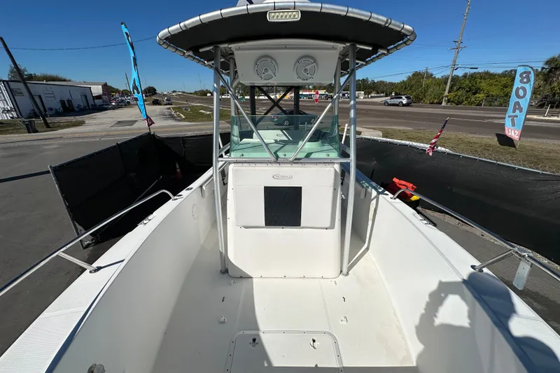 Slide: The Image of 1999 Robalo 2420 Center Console boat, docked, showcasing spacious deck and sturdy T-top. - 41
