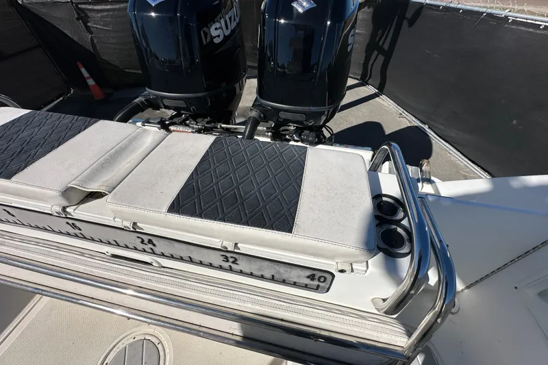 Slide: The Image of 1999 Robalo 2420 Center Console boat with dual Suzuki engines and cushioned seating. - 51