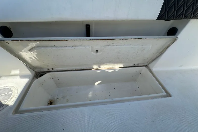 Slide: The Image of Open storage compartment on a 1999 Robalo 2420 Center Console boat. - 55