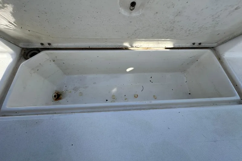 Slide: The Image of Open storage compartment on a 1999 Robalo 2420 Center Console boat. - 56