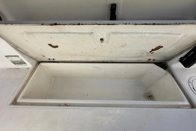 Slide: The Image of Open storage compartment on a 1999 Robalo 2420 Center Console boat. - 58