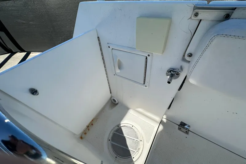 Slide: The Image of 1999 Robalo 2420 Center Console interior with storage compartment and seating area. - 60