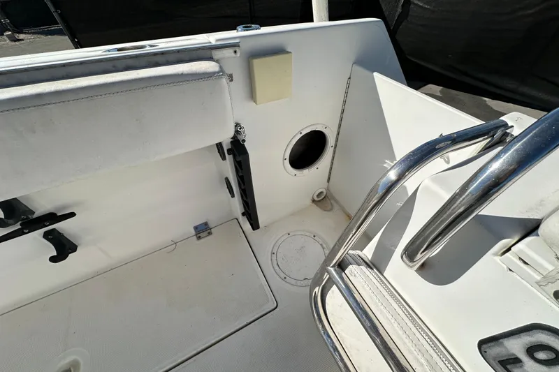 Slide: The Image of 1999 Robalo 2420 Center Console boat interior with seating and stainless steel railings. - 62