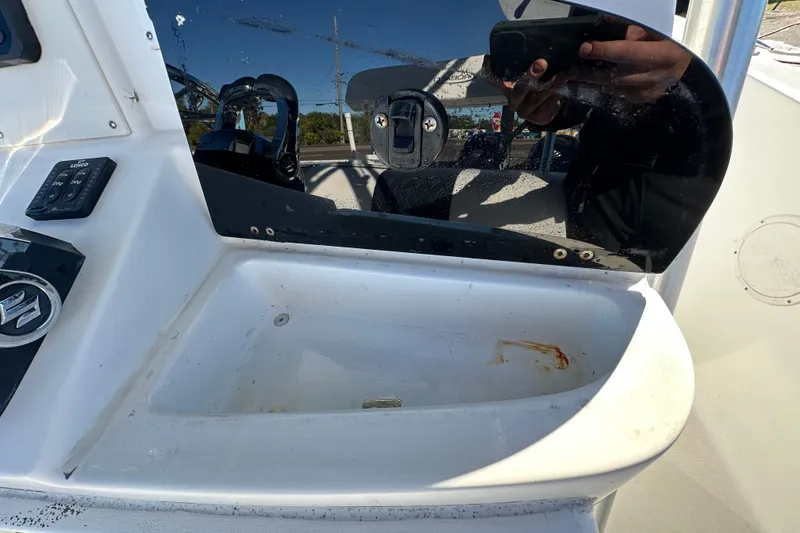 Slide: The Image of 1999 Robalo 2420 Center Console boat dashboard with controls and reflection. - 66