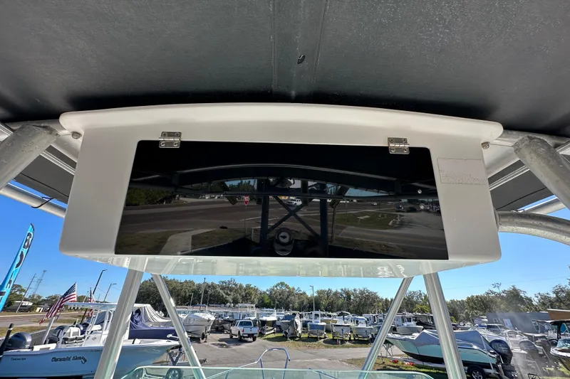 Slide: The Image of 1999 Robalo 2420 Center Console boat with overhead storage compartment, marina background. - 67