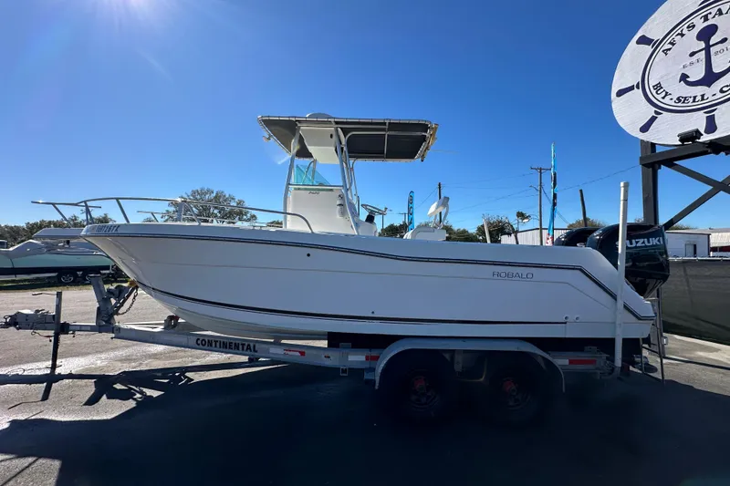 Slide: The Image of 1999 Robalo 2420 Center Console boat on trailer, displayed outdoors under clear sky. - 7
