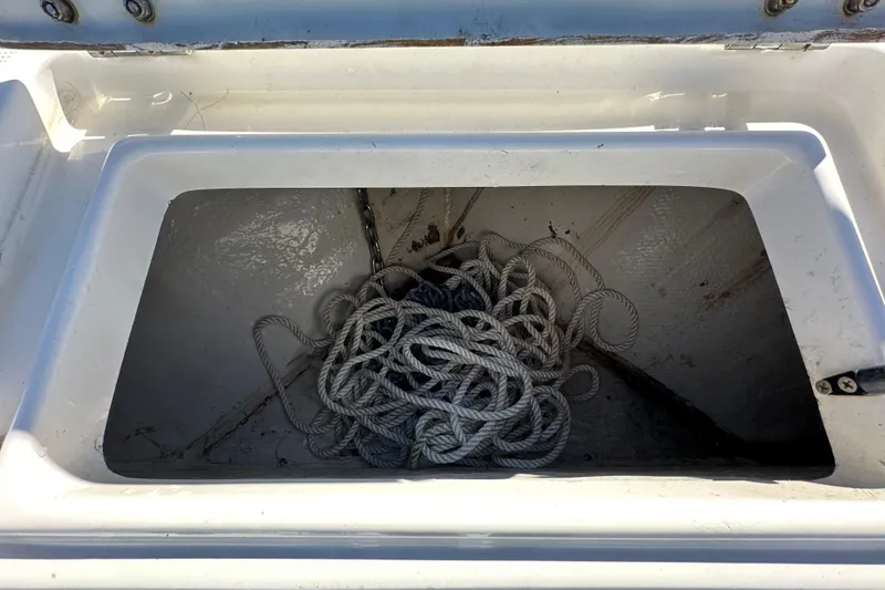 Slide: The Image of Storage compartment with coiled rope on a 1999 Robalo 2420 Center Console boat. - 79