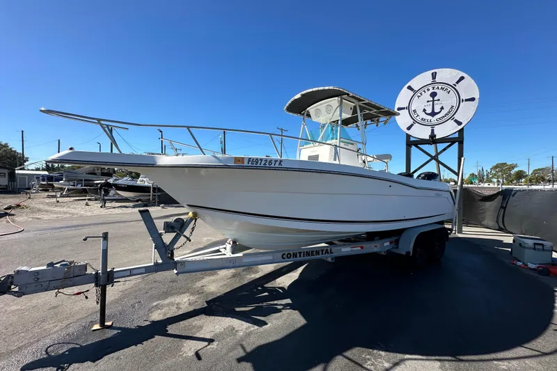 Slide: The Image of 1999 Robalo 2420 Center Console boat on trailer at a dealership under clear blue sky. - 8