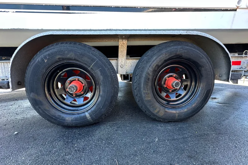 Slide: The Image of Trailer wheels of a 1999 Robalo 2420 Center Console boat on asphalt. - 81
