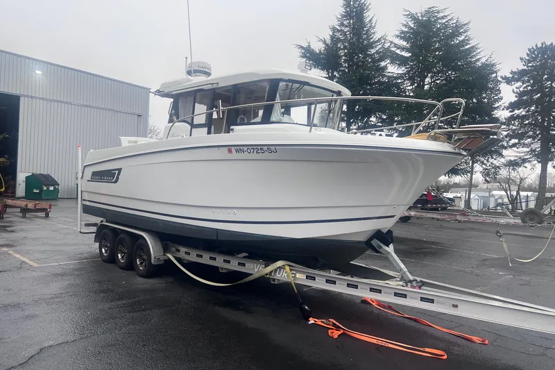 Slide: The Image of 2015 Jeanneau Merry Fisher 855 Marlin boat on trailer, parked outdoors. - 1