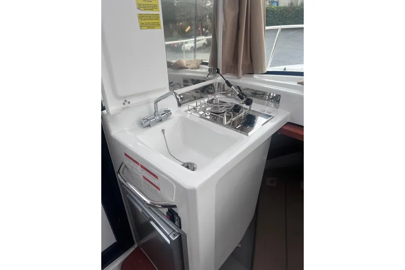 Slide: The Image of 2015 Jeanneau Merry Fisher 855 Marlin boat kitchen with sink and stove. - 12