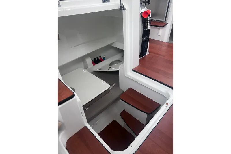 Slide: The Image of 2015 Jeanneau Merry Fisher 855 Marlin interior with wooden steps and storage area. - 14