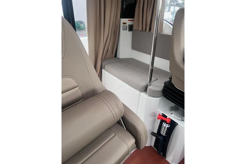 Slide: The Image of Interior of 2015 Jeanneau Merry Fisher 855 Marlin with beige seating and curtains. - 15