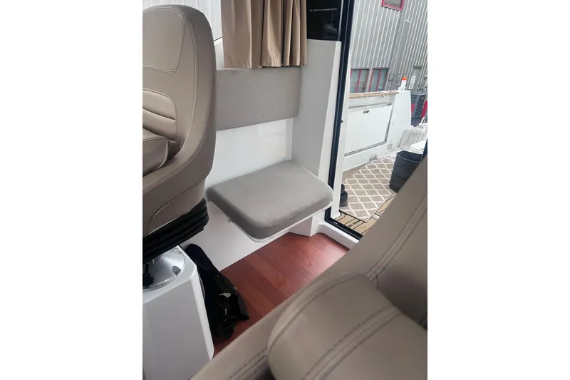 Slide: The Image of Interior of 2015 Jeanneau Merry Fisher 855 Marlin, featuring seating and open door. - 16