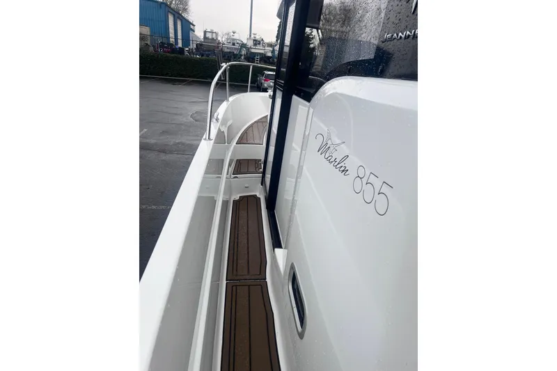Slide: The Image of 2015 Jeanneau Merry Fisher 855 Marlin boat, side view with sleek design and wood accents. - 21