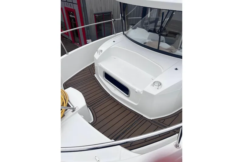 Slide: The Image of 2015 Jeanneau Merry Fisher 855 Marlin boat deck with wood finish and railing. - 24