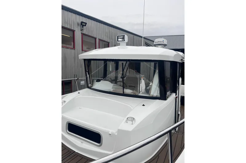 Slide: The Image of 2015 Jeanneau Merry Fisher 855 Marlin boat docked near a building. - 25