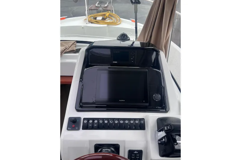 Slide: The Image of 2015 Jeanneau Merry Fisher 855 Marlin helm with navigation controls and display. - 27