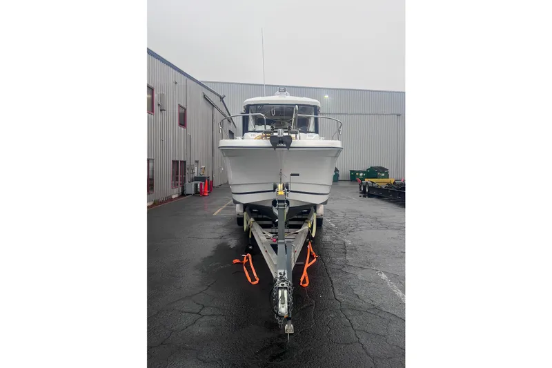 Slide: The Image of 2015 Jeanneau Merry Fisher 855 Marlin boat on trailer in industrial setting. - 3