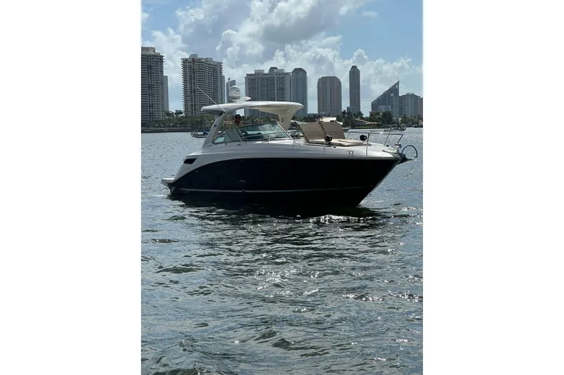 Slide: The Image of 2016 Sea Ray 350 Sundancer yacht on water with city skyline background. - 2