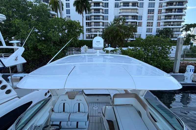 Slide: The Image of 2016 Sea Ray 350 Sundancer yacht docked near waterfront buildings and lush greenery. - 22