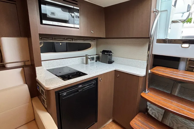 Slide: The Image of Modern kitchen in 2016 Sea Ray 350 Sundancer yacht with sleek appliances and wooden cabinetry. - 30