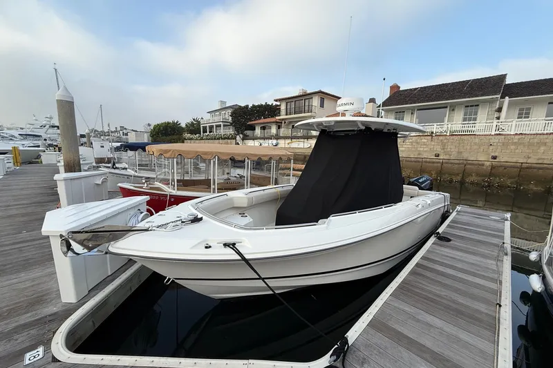 Slide: The Image of 2025 Boston Whaler 250 Outrage docked at marina, featuring sleek design and modern amenities. - 13