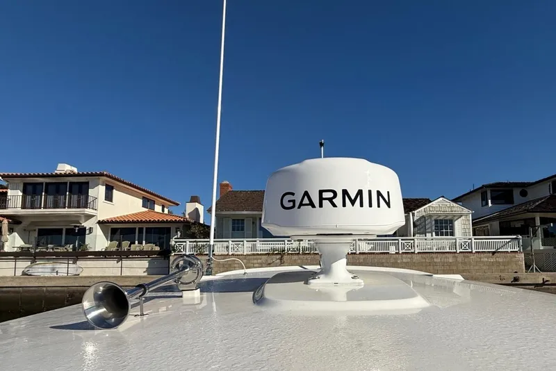 Slide: The Image of 2025 Boston Whaler 250 Outrage with Garmin radar, docked near waterfront homes. - 15