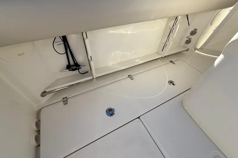 Slide: The Image of 2025 Boston Whaler 250 Outrage storage compartment with hoses and equipment. - 24