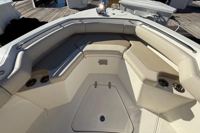 Slide: The Image of 2025 Boston Whaler 250 Outrage boat interior with cushioned seating and a wooden table. - 40